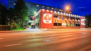 A hotel with a prominent DZINGEL sign, a modern building with a flat roof, and a well-lit entrance. - Hotel Dzingel (Tallinn)