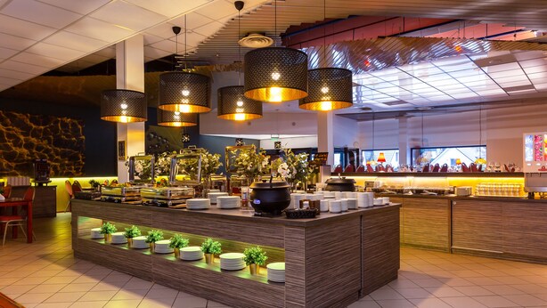 A buffet area with a central island, overhead lighting, and a modern interior design. - Hotel Dzingel (Tallinn)