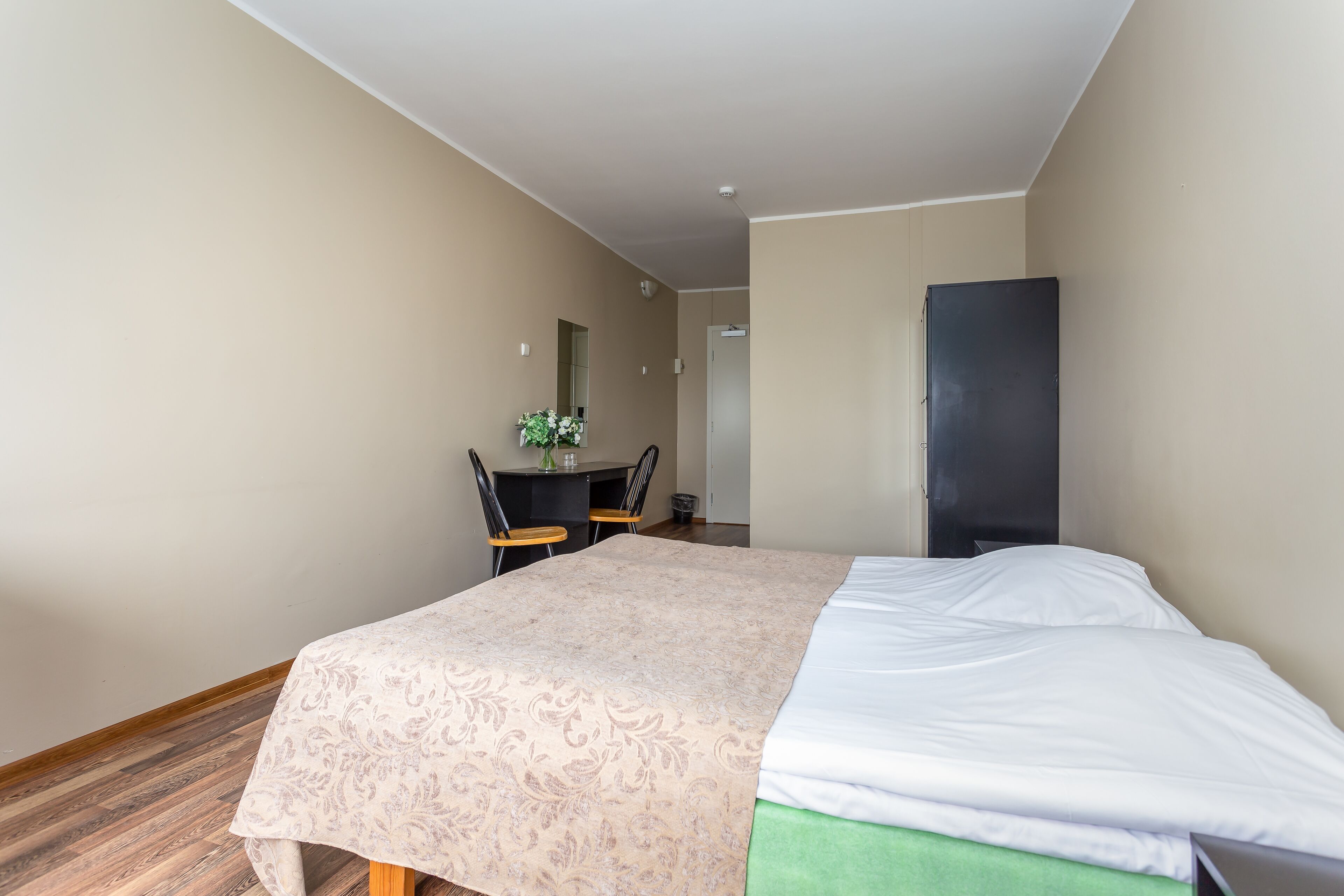 Una habitación de hotel con una cama, un escritorio y una silla.