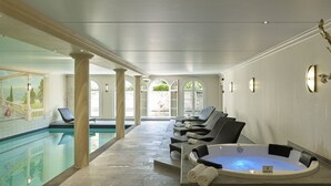 Een wellnessruimte met een zwembad, ligbedden en een jacuzzi.