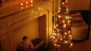 A cozy room with a fireplace, a Christmas tree, and a small Santa figurine.
