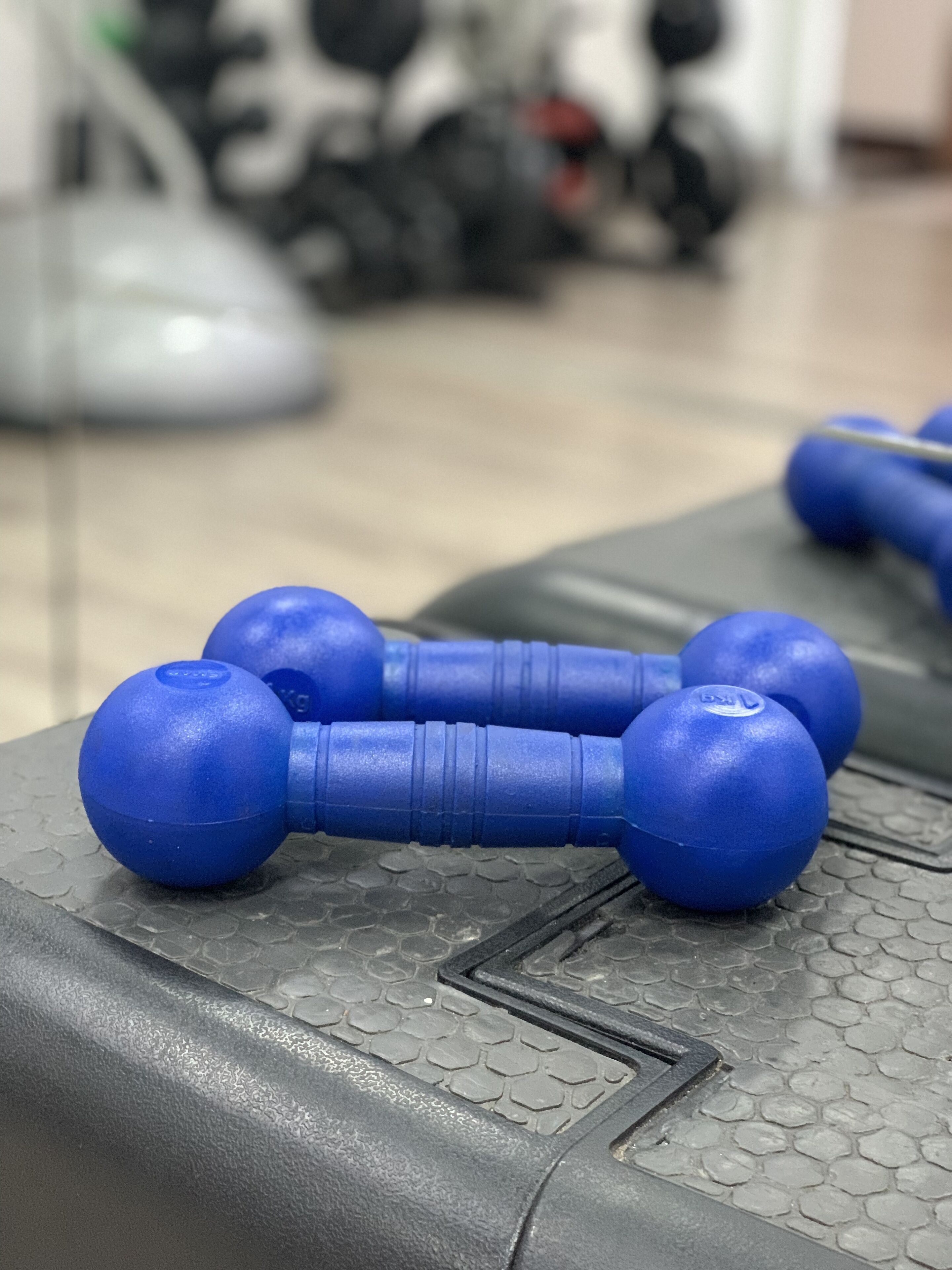 Een set blauwe haltergewichten op een geribbelde mat.