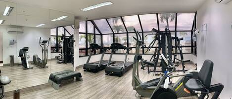 A gym with treadmills, elliptical machines, and weight equipment.