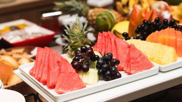 A buffet with various fruits and pastries.