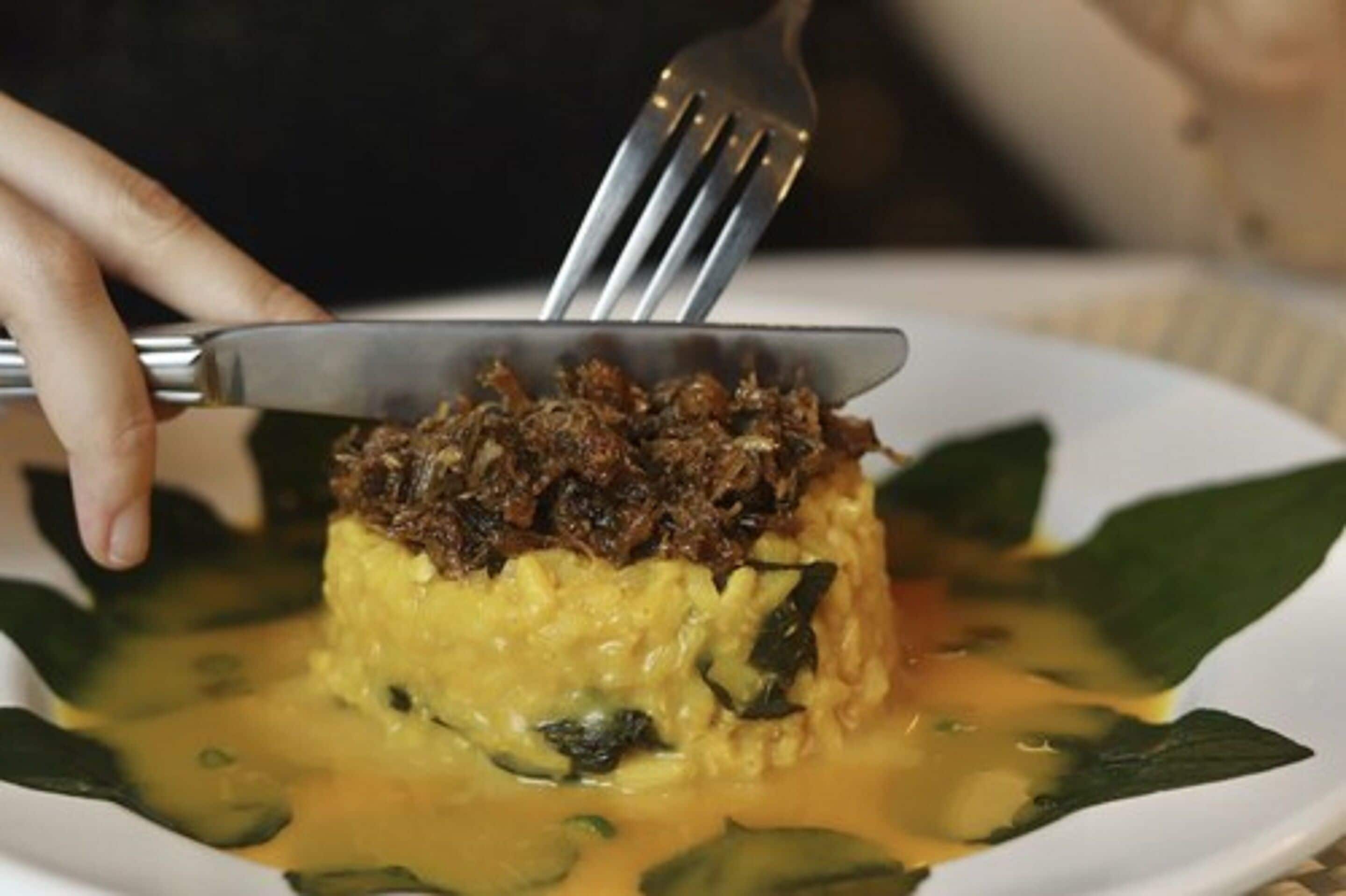 Una persona usa un tenedor para servir comida de un plato.