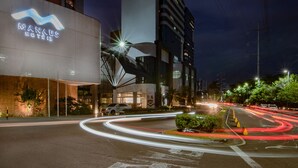 A modern hotel with a prominent sign, a curved glass facade, and a well-lit entrance. - Manaus Hotéis - Millennium (Manaus)