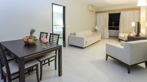 A modern hotel room with a dining table, a sofa, and a TV. - Hotel Saint Paul (Manaus)