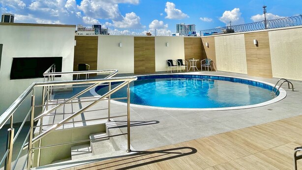 A rooftop pool with a clear blue sky, a wooden deck, and a few lounge chairs. - Hotel Saint Paul (Manaus)