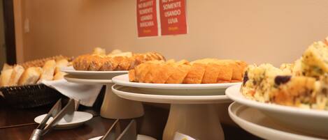 A buffet table with various dishes, including a cake of cassava, and a sign indicating no buffet buffets.