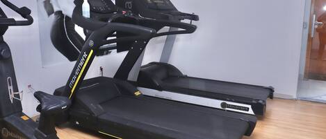 A treadmill with a digital display and a water bottle on the console.