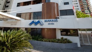 A modern hotel building with a prominent sign for "MANHAUS HOTELS". - Hotel Adrianópolis All Suites (Manaus)