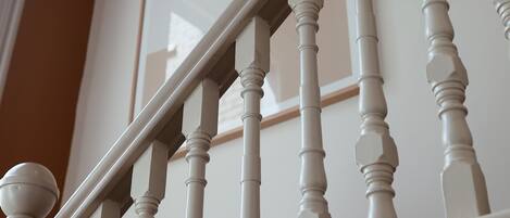 Una escalera con balaustres blancos y barandilla.