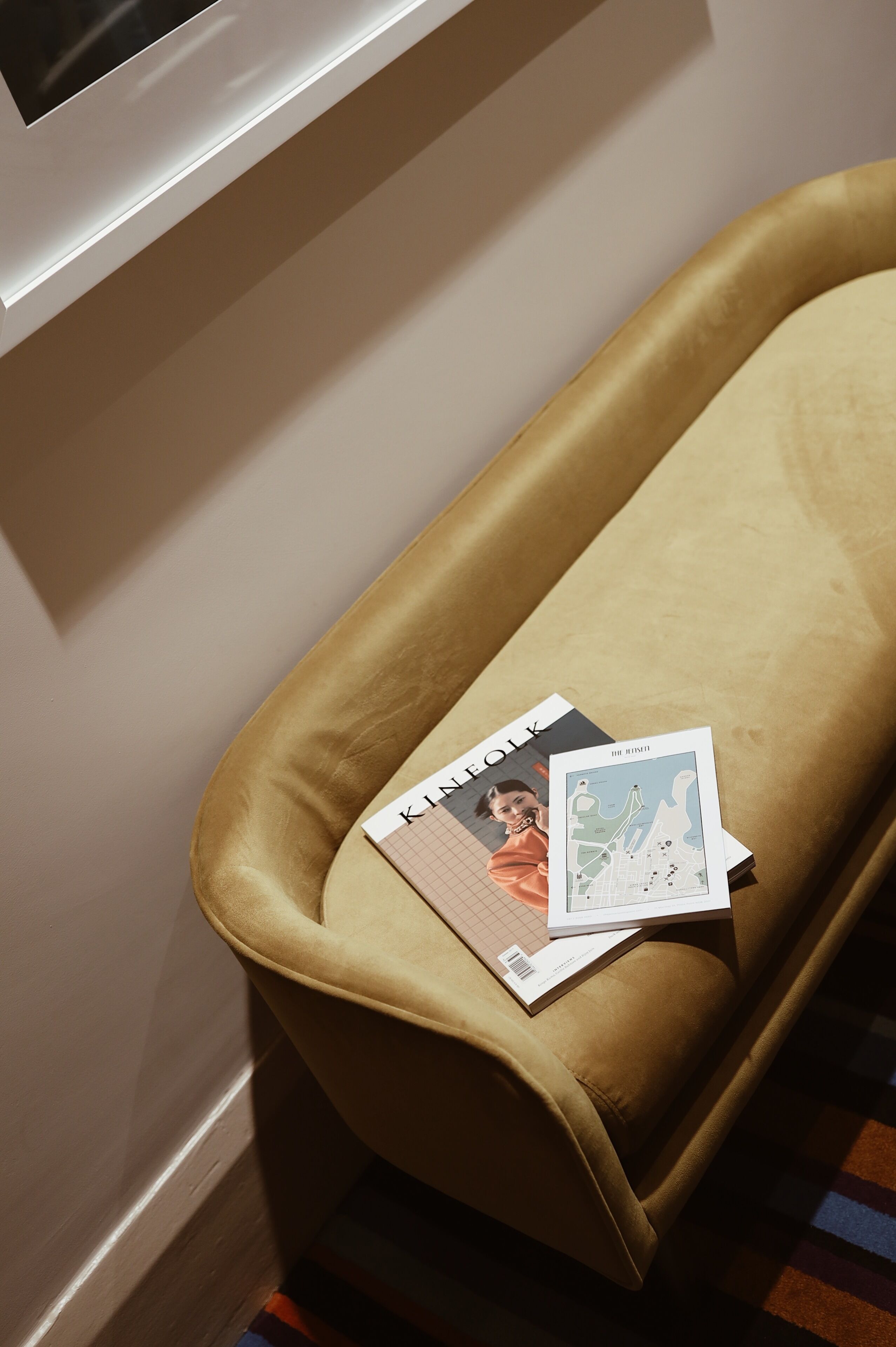 A room with a brown sofa and a window.