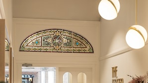 A reception area with a modern design, including a reception desk, seating area, and a decorative stained glass window.