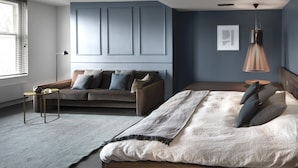 Ein modernes Schlafzimmer mit einem Bett, einer Couch und einer Lampe.