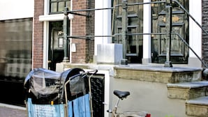 Ein Fahrrad neben einem Gebäude mit einer schwarzen Tür und einem Fenster mit weißem Rahmen.