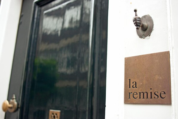 Una puerta con picaporte de latón y placa que dice 'la remise'.