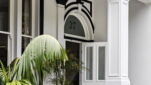Un edificio con fachada blanca, detalles en negro y el número '37' sobre una puerta.