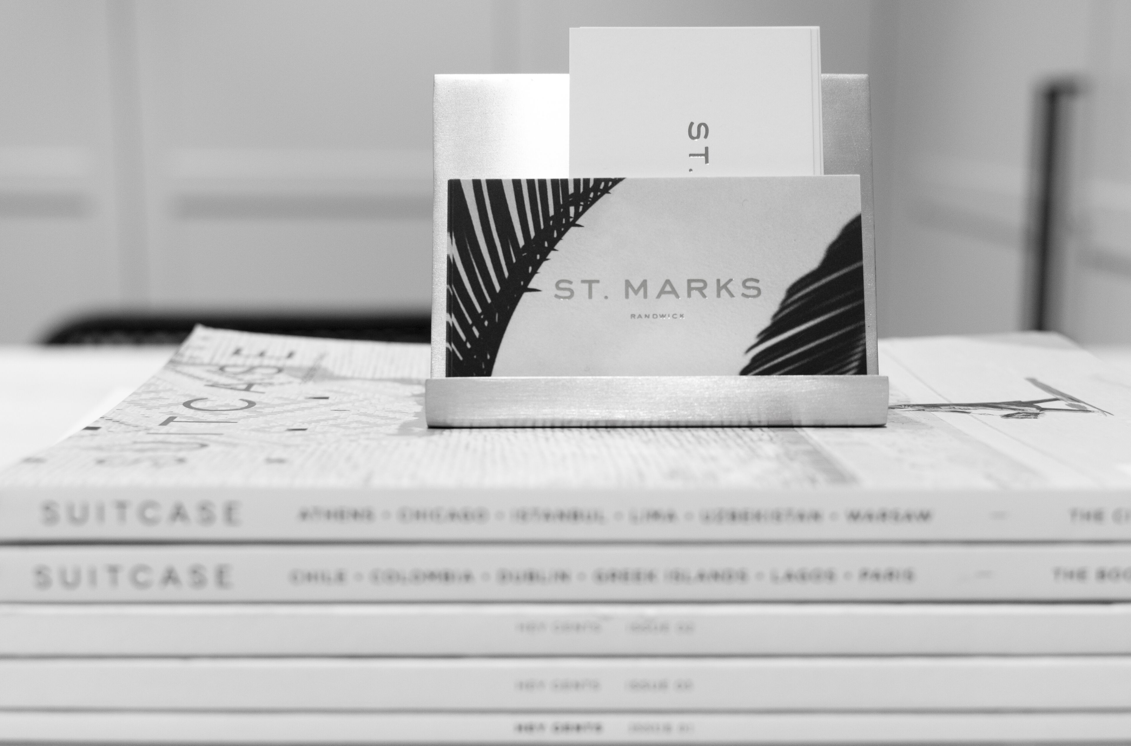 A stack of books with a visible book titled 'SUITCASE' and another book titled 'ST. MARKS'.