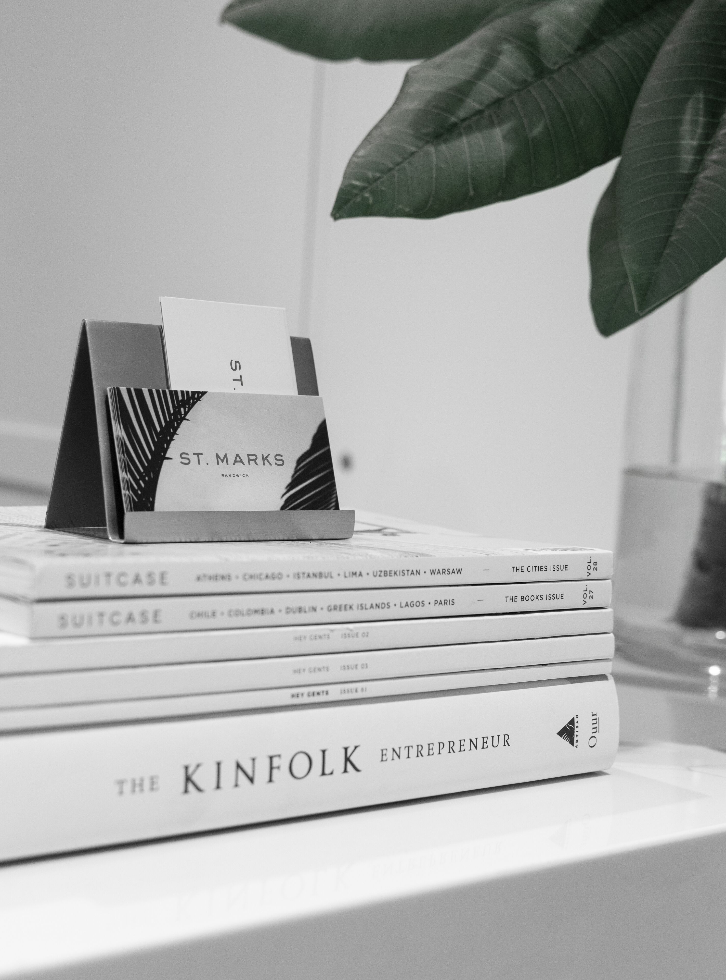A stack of books with visible titles and a card holder with a card labeled "ST. MARKS".