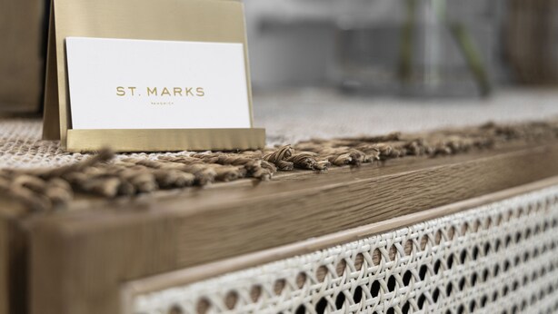 Una tarjeta con la inscripción "ST. MARKS" sobre una superficie trenzada.