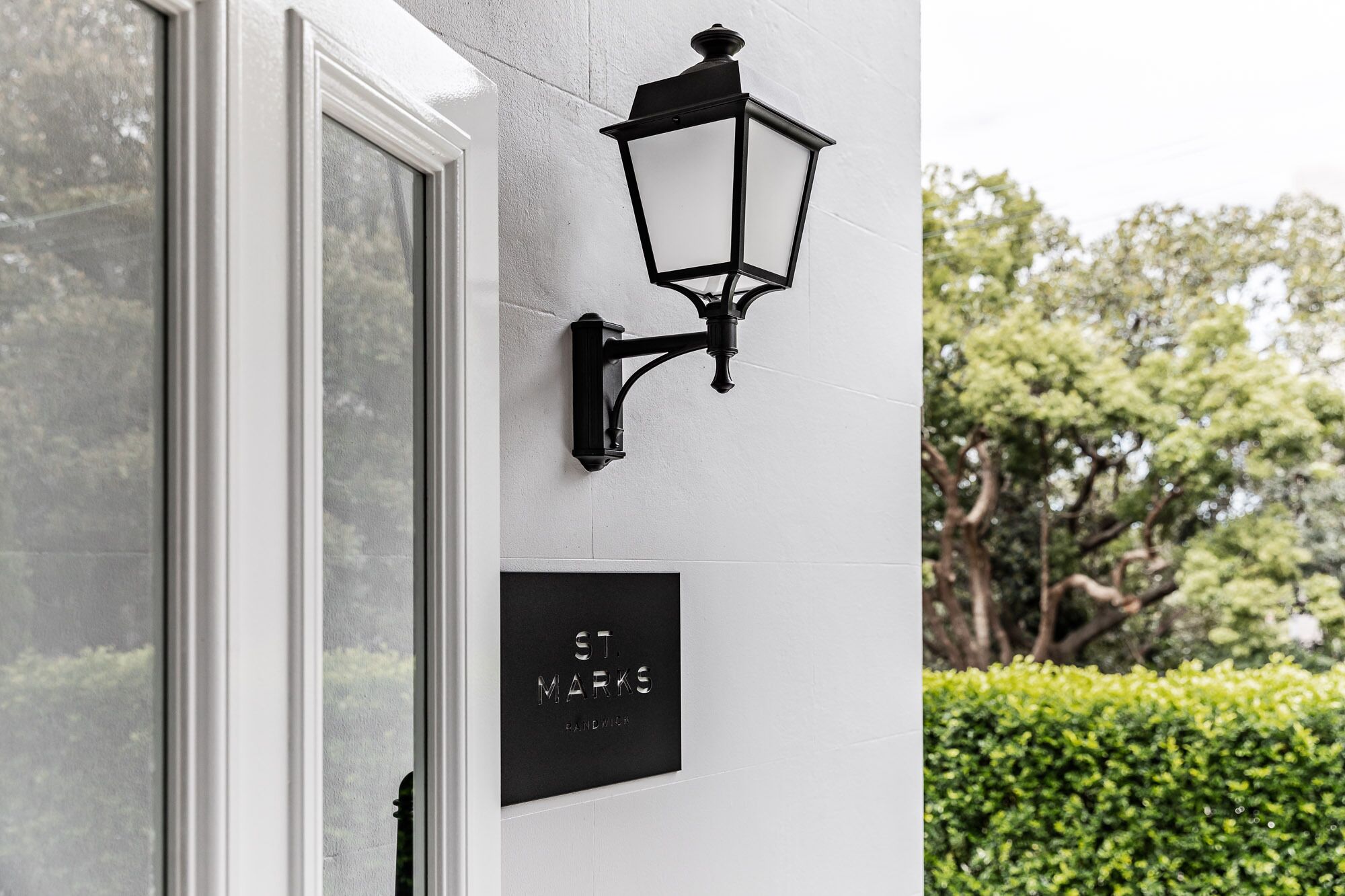 A black wall-mounted light fixture and a sign with "ST MARKS" and "PANDAMICK" text.