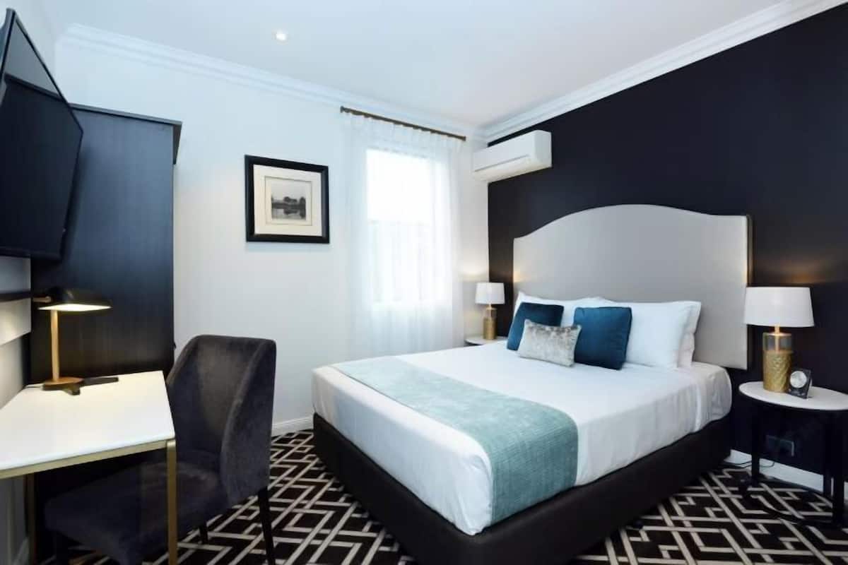 Premium bedding, desk, laptop workspace, blackout drapes