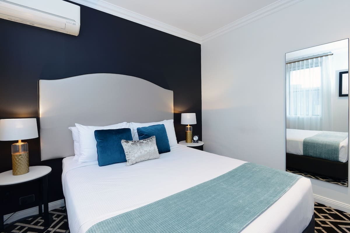 Premium bedding, desk, laptop workspace, blackout drapes