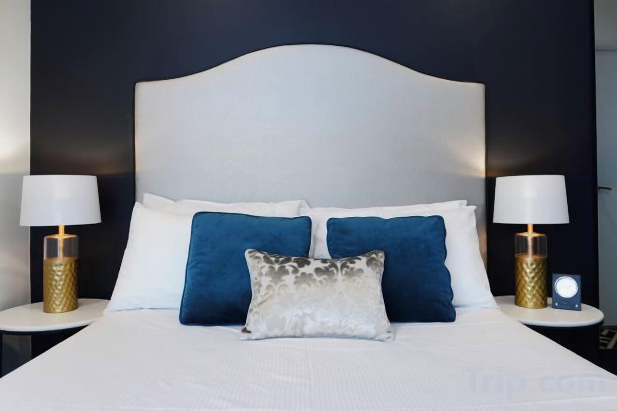 Premium bedding, desk, laptop workspace, blackout drapes