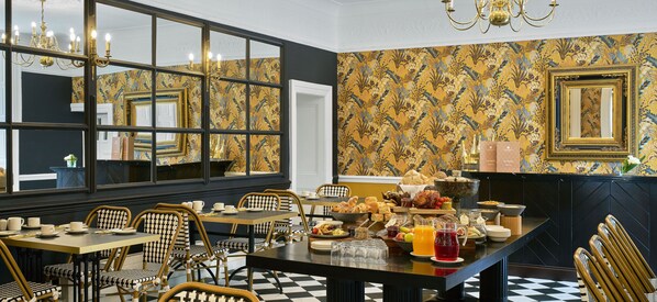 A dining area with a checkered floor, chessboard-patterned chairs, a buffet table with various dishes, and a large window with a view. - Summerhill House Hotel (Enniskerry)