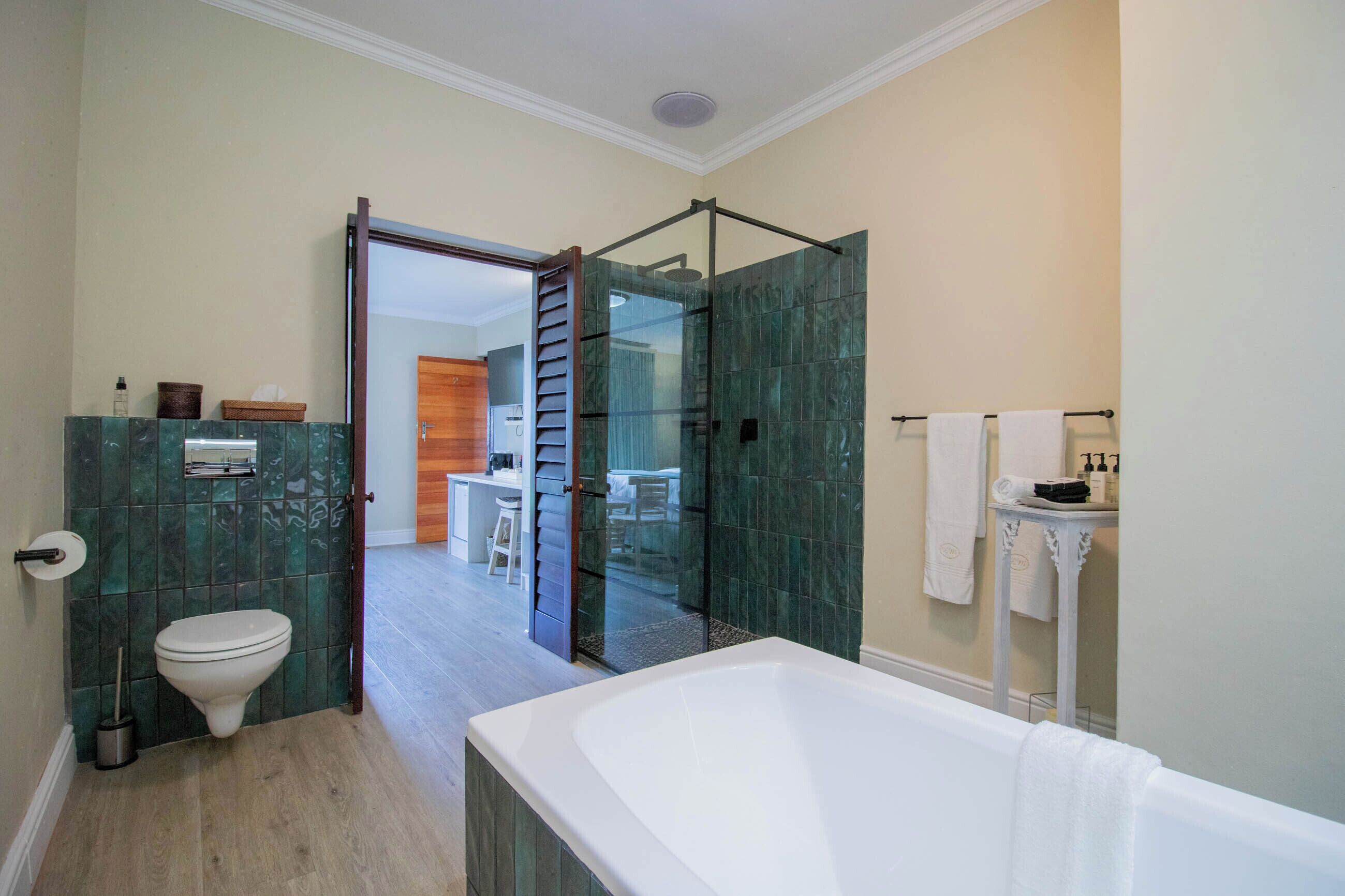 Een moderne badkamer met een douchecabine van glas, een wit bad en een toilet.