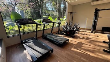 A gym with treadmills, exercise bikes, and a pull-up bar.