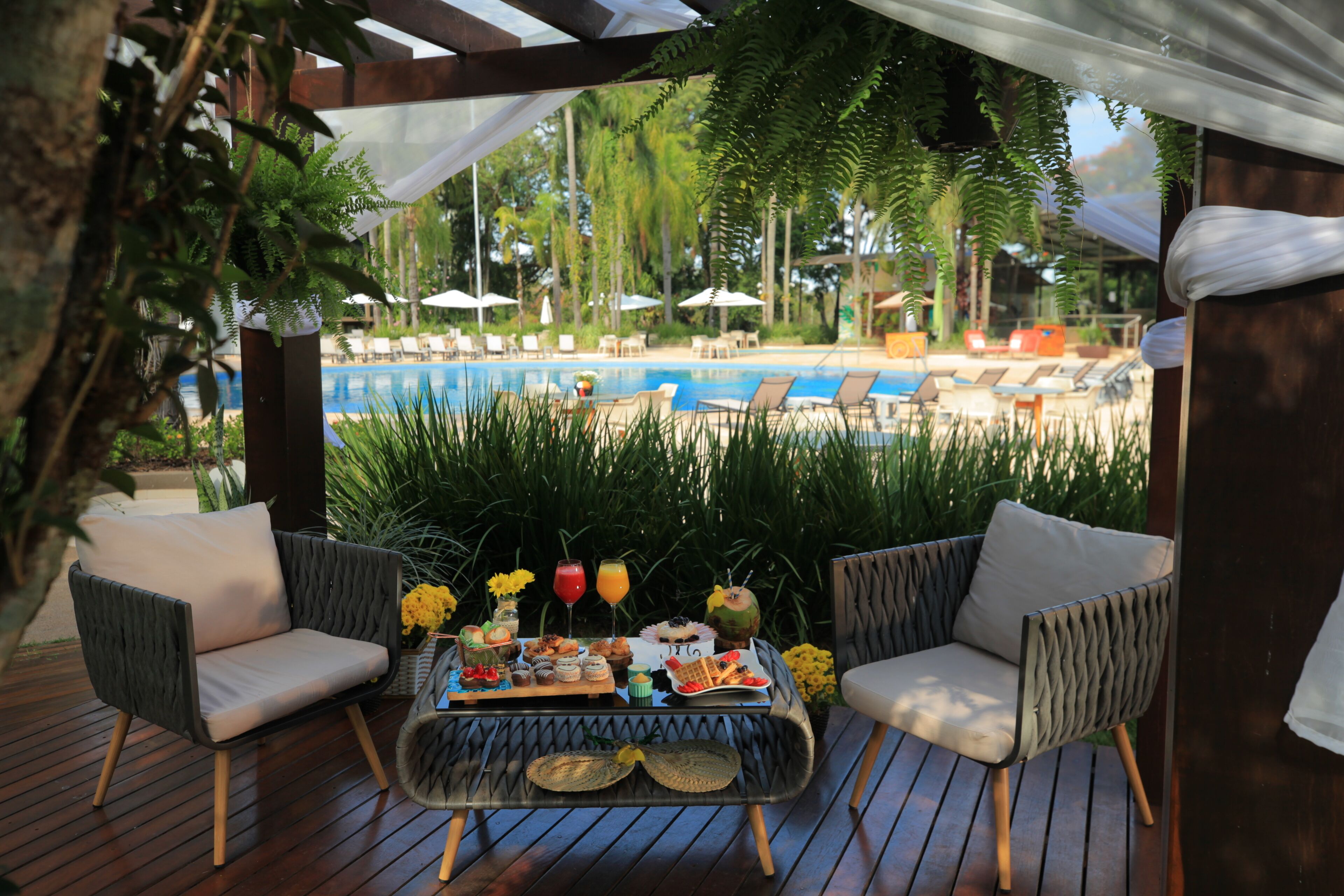 Una piscina techada, una piscina al aire libre, sombrillas