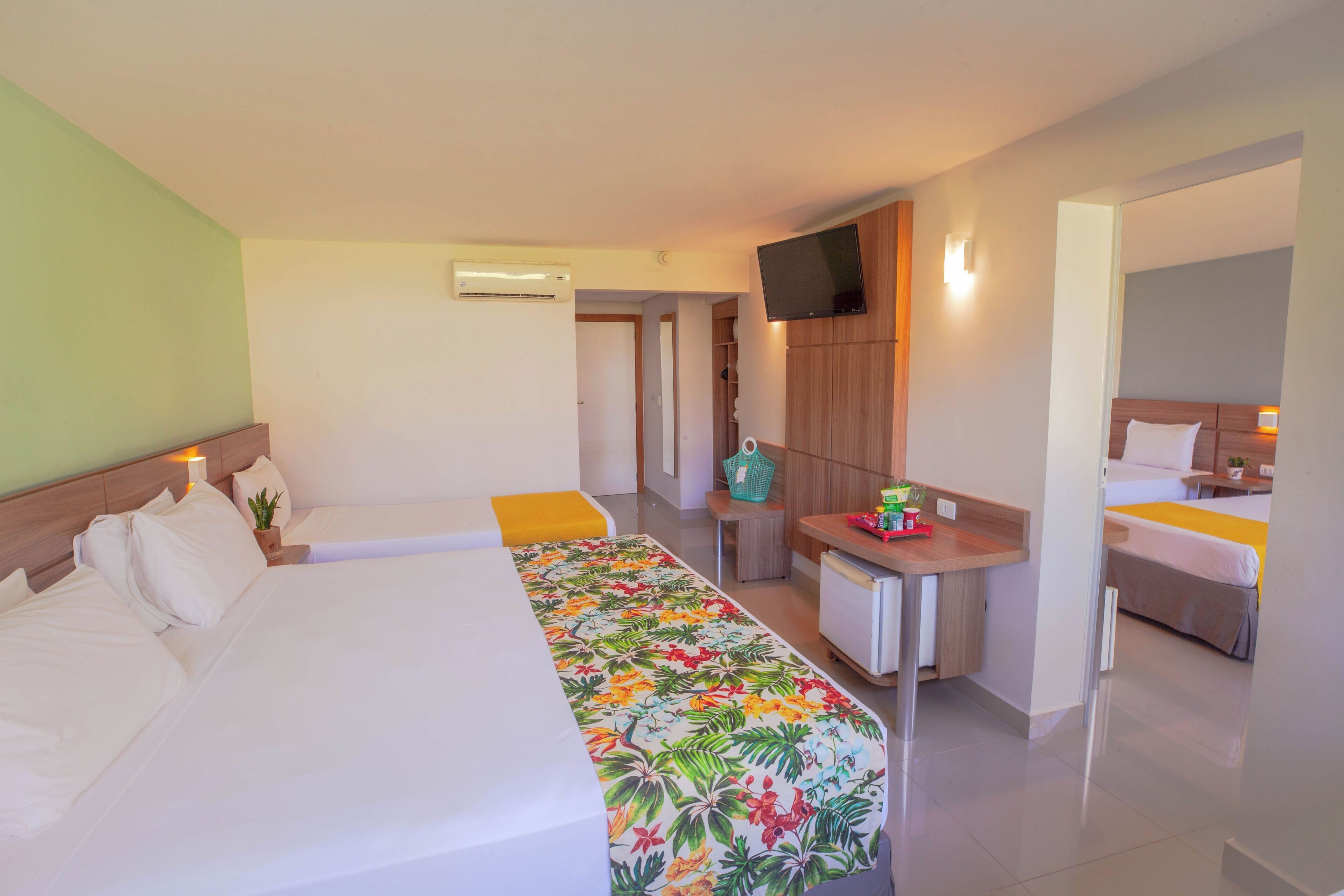 Una habitación de hotel con dos camas, un escritorio, televisor y baño.