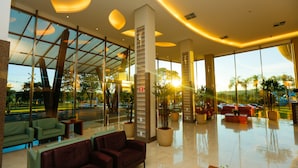 A spacious lobby with large windows, modern furniture, and a clean, reflective floor.