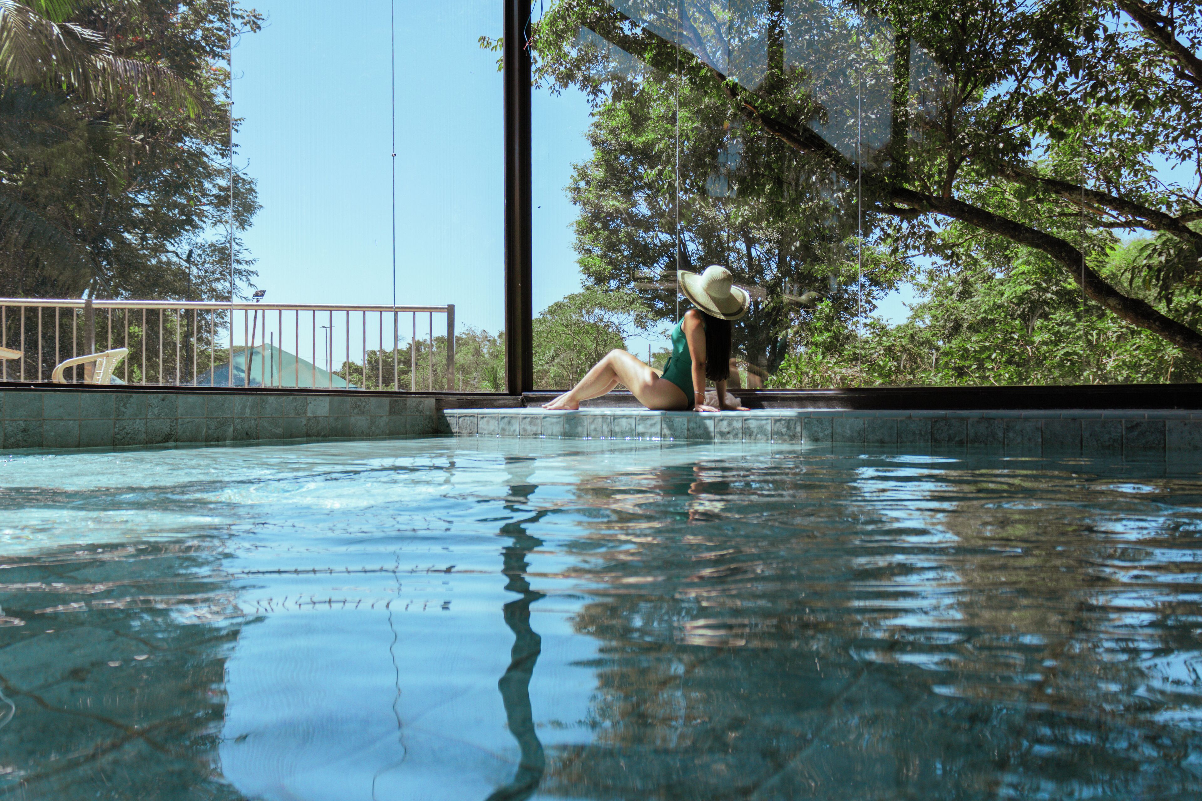 Alberca techada, alberca al aire libre y sombrillas en la alberca