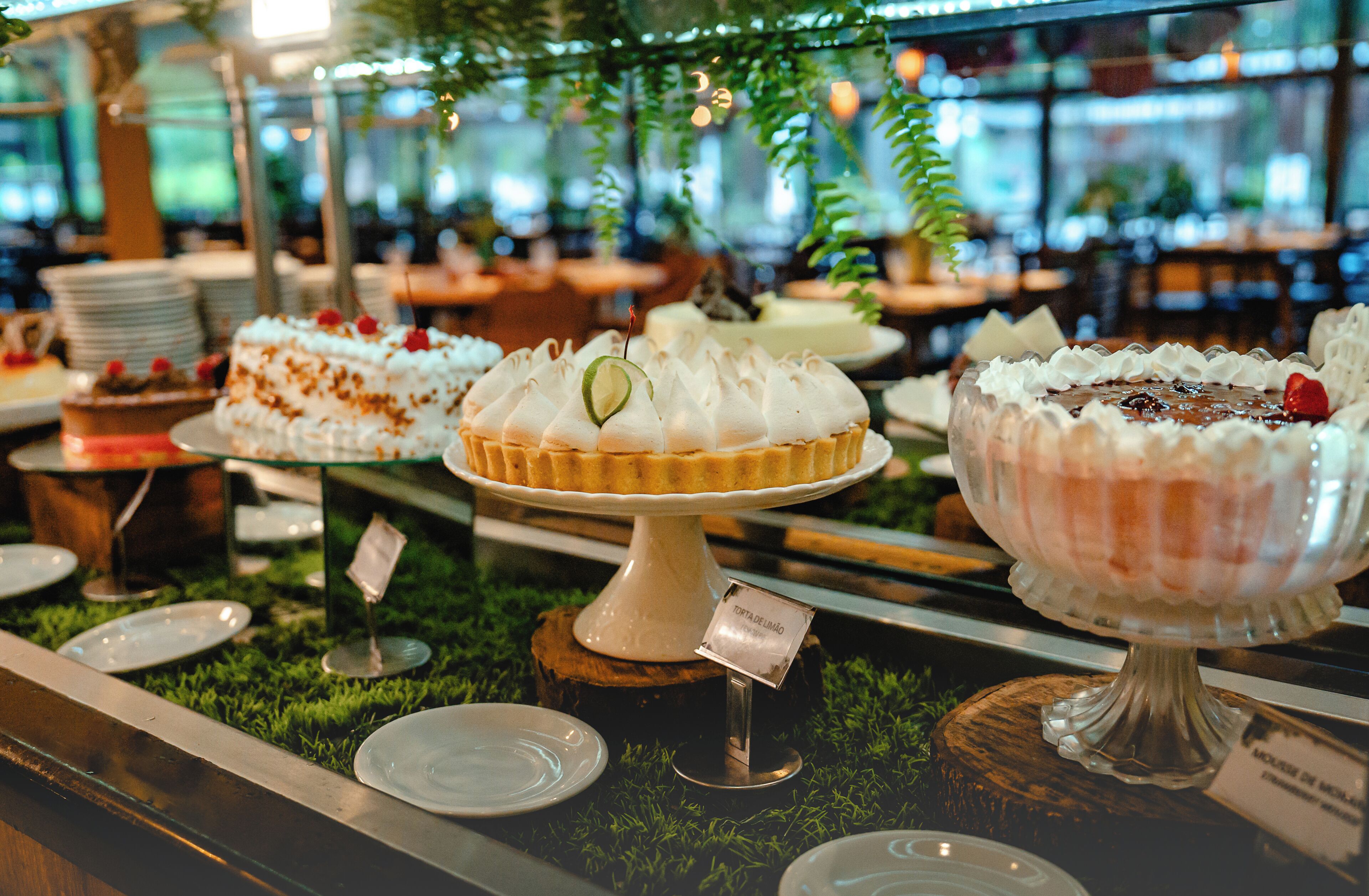 A dessert display with various cakes and pastries on stands.