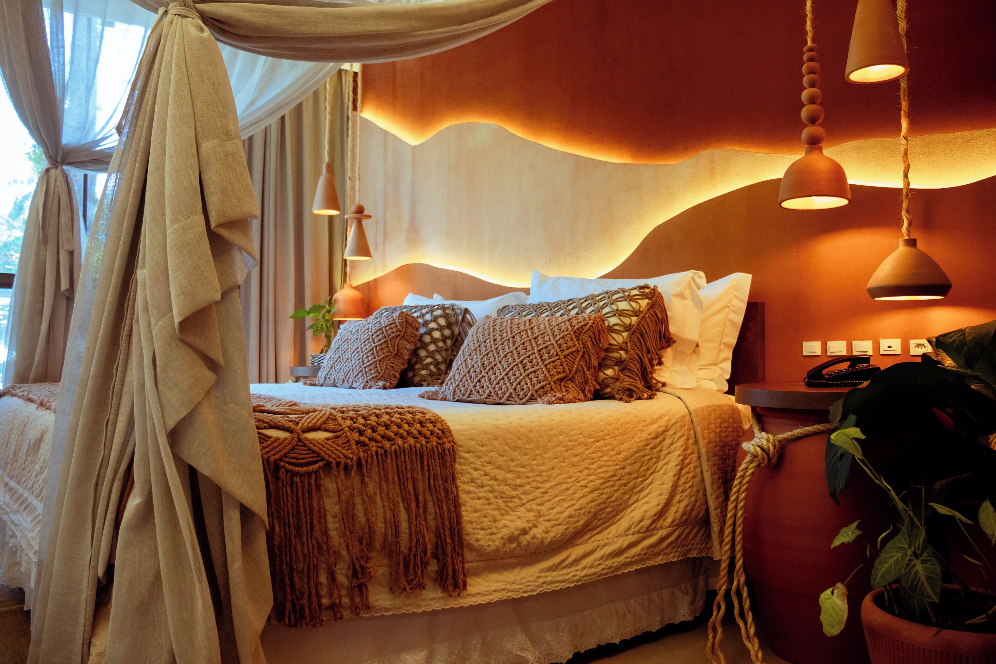 A bedroom with a bed, bedside table, and curtains.