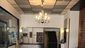 A modern kitchen with a central island, a chandelier, and a patterned floor. - Hôtel Océan (Lourdes)