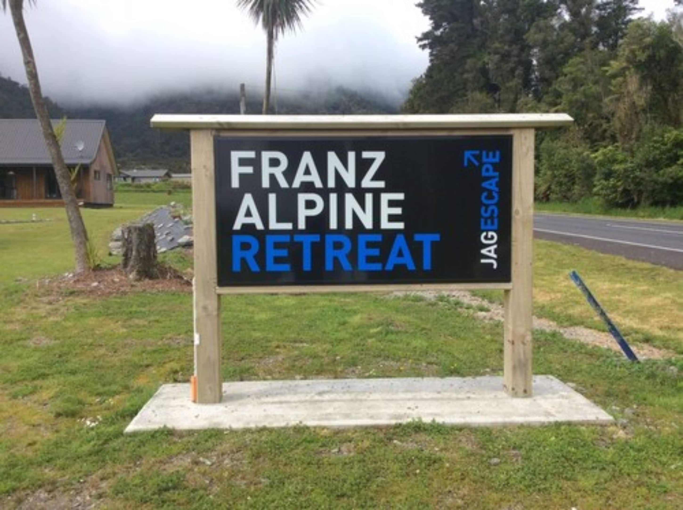 Un letrero para Franz Alpine Retreat con el logotipo JAG Escape.