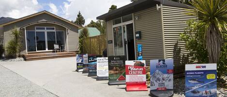 Un edificio con una antena parabólica, un cartel para el Centro de Vida Silvestre y otro cartel para Vuelos Panorámicos.