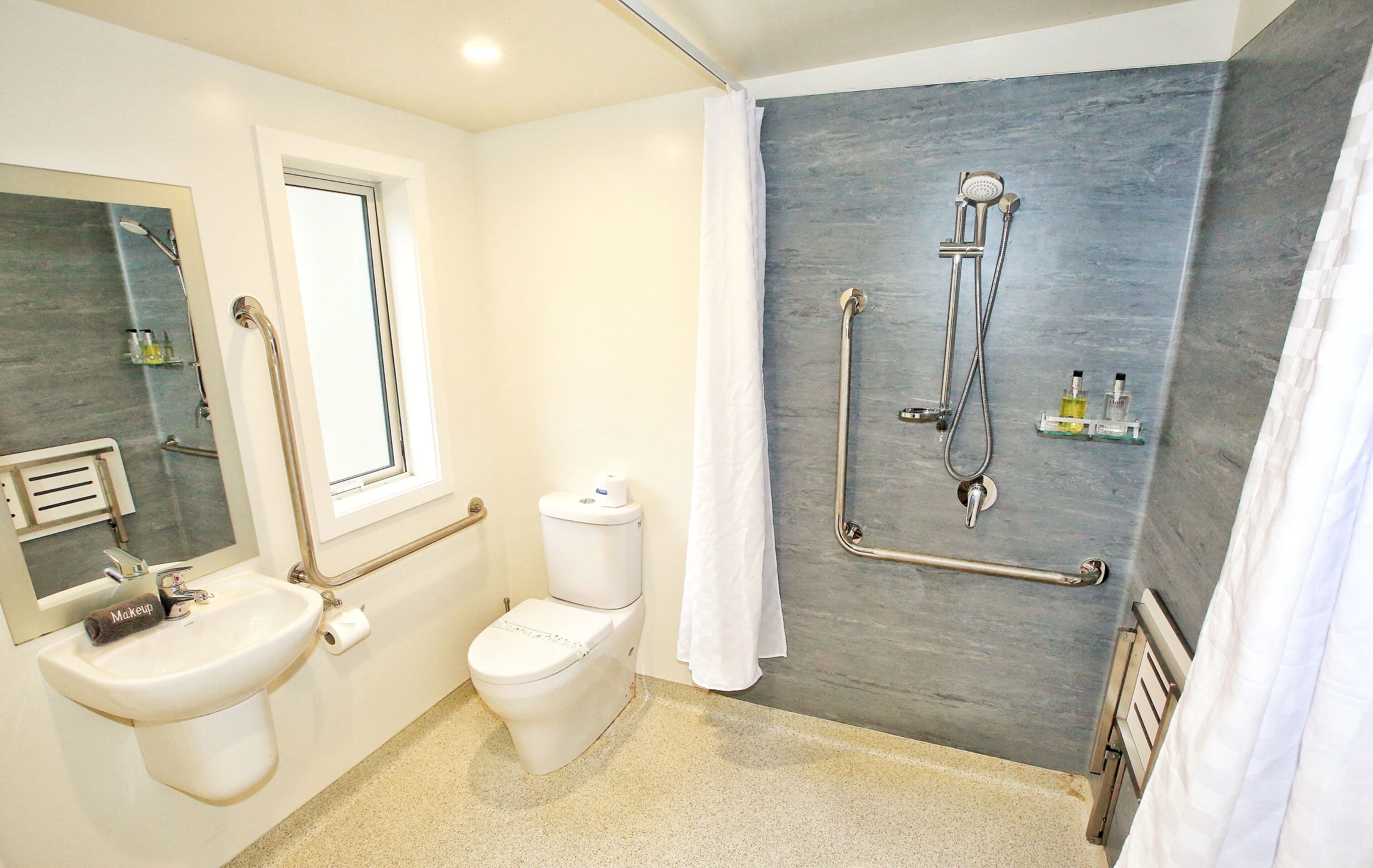 Un bany modern amb un lavabo, vàter i plat de dutxa.