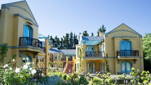 A yellow building with blue shutters and a balcony. - Franschhoek Country House and Villas (Franschhoek)