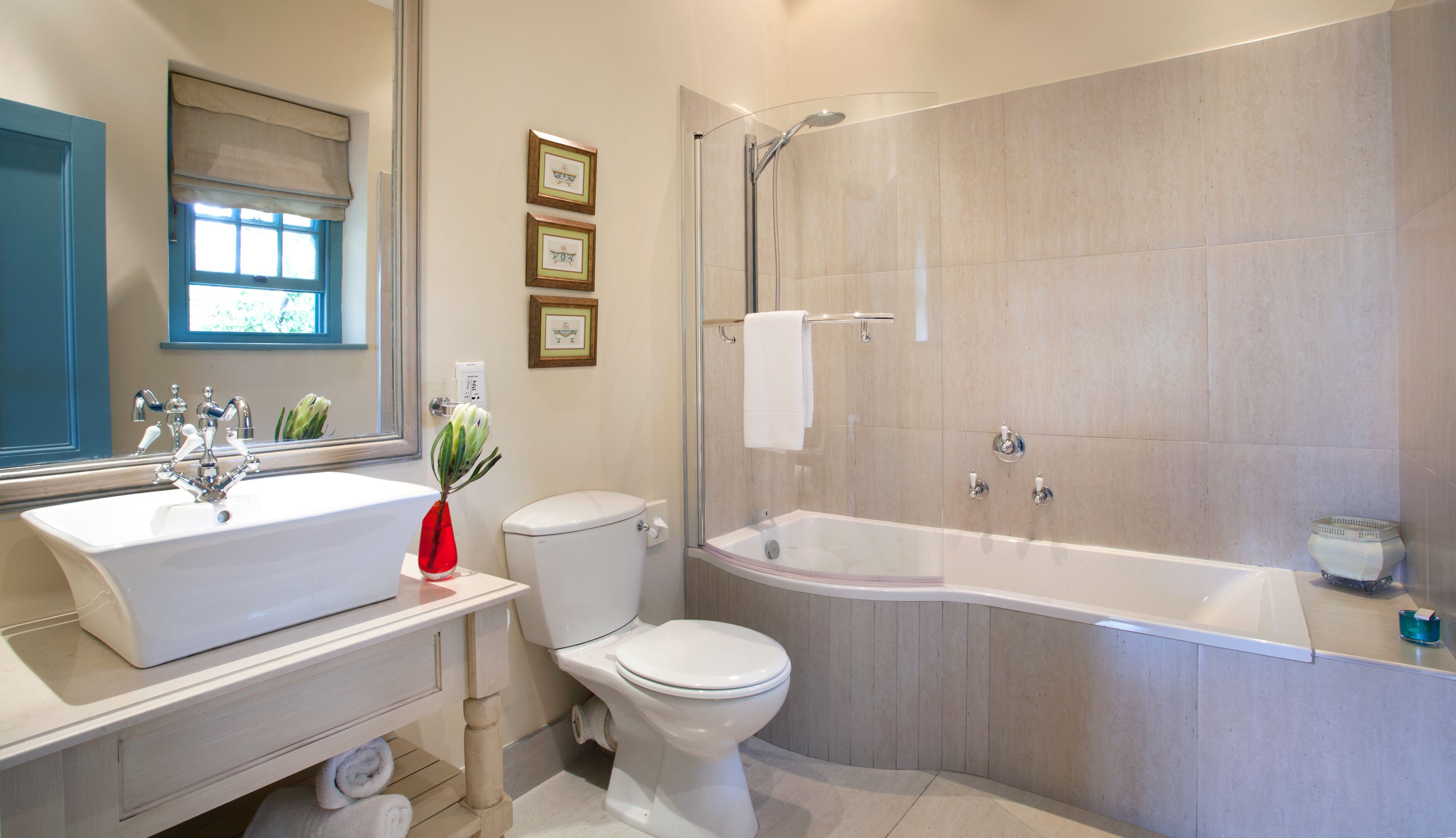 A modern bathroom with a double sink, toilet, and a walk-in shower.