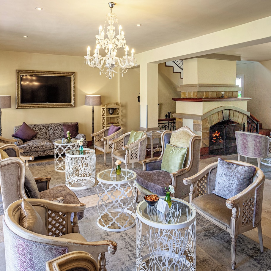 A spacious living room with a fireplace, multiple seating arrangements, and decorative lighting.