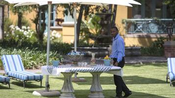 Un espace jardin aménagé avec une table, des chaises et une fontaine.