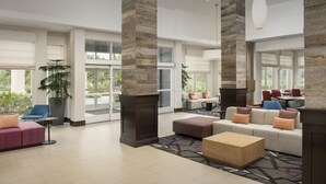 A spacious lobby with a large seating area, a coffee table, and a potted plant.
