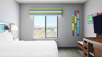 Habitación de hotel con una cama grande, un escritorio, una silla, un ventanal con vistas al desierto y una obra de arte colorida en la pared.