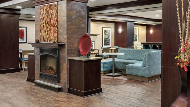 A lobby with a fireplace, seating area, and a decorative wall.