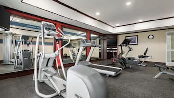 Un gimnasio moderno con varios equipos de ejercicio, incluyendo cintas de correr y una bicicleta estática.